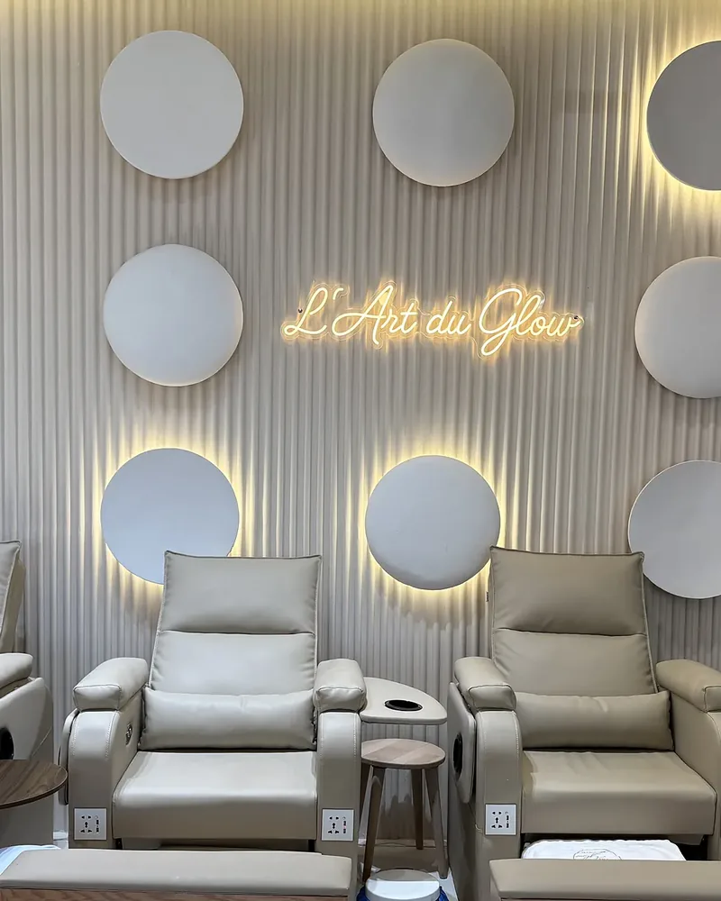 Les fauteuils de pédicure sous l'enseigne lumineuse L'Art du Glow et les disques éclairés